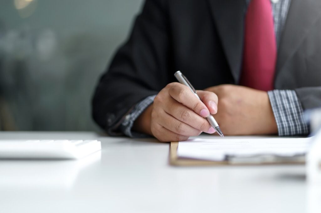 Signing a home loan purchase agreement with a real estate agent.